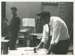 Man sketches with charcoal, circa late 1950's - early 1960's.