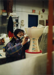 Woman paints ceramic, circa 1990s.