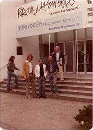 Men pose at art gallery entrance, circa 1990s.