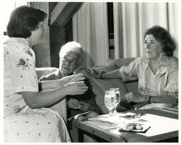 Women talk at event, circa 1986-1995.