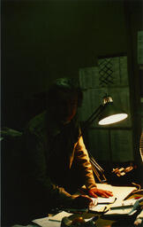 Man writes at desk, date unknown.