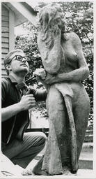Man works on sculpture with chisel, date unknown.