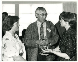 Steve Wong and women talk at event, circa 1986-1995.